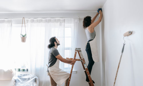 A couple painting a room together